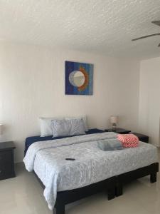 a bedroom with a bed and a painting on the wall at Depa vista al mar in Playa del Carmen +9 photos