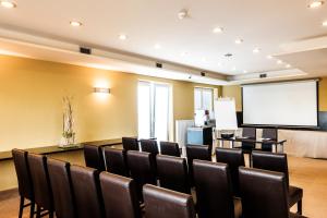 a conference room with a table and chairs and a screen at Hotel Comfort with free Wellness and Fitness Centrum in Nitra