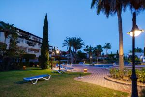 a park with benches and palm trees at night at Heavenly Homes Mojcar 93 in Mojácar