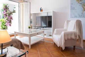 a living room with a tv and a chair and a table at Heavenly Homes Mojcar 93 in Mojácar