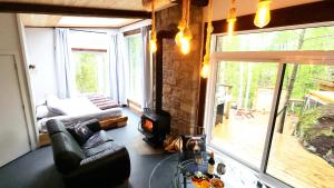 a living room with a couch and a fireplace at La Cache de l'Ours - Thermal Experience Spa&Sauna in Saint-Alexis-des-Monts