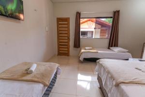 a room with two beds and a window at Pousada Aurora Boreal 2 in Alter do Chao
