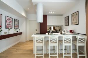 Ace of Hearts 1 BR APARTMENT,Parking, Fast wi-fi in One Cotroceni في بوخارست: مطبخ مع جزيرة بيضاء مع كراسي