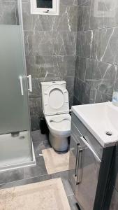 a bathroom with a toilet and a sink at One Bed apartment -East London in London