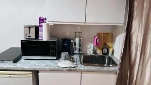 a kitchen counter with a sink and a microwave at One Bed apartment -East London in London