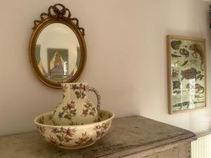a vase sitting on a table in front of a mirror at Halte dans le Perche  +4 photos