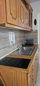 una cucina con lavello e mobili in legno di Blue View a Qeparo