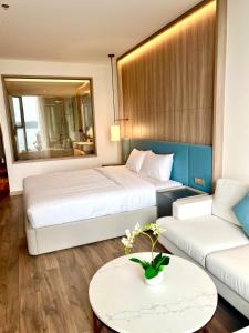 una habitación de hotel con dos camas y un sofá en Alacater hạ long bay, en Ha Long
