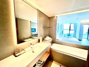 Un baño con lavabo y un espejo grande. en Alacater hạ long bay, en Ha Long