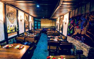 a restaurant with tables and chairs and paintings on the walls at Family hotel Valchanovata Kashta in Fotinovo +44 photos