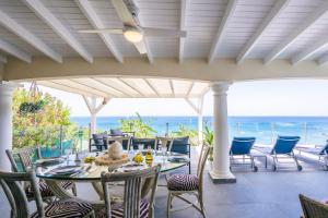 eine Terrasse mit Tisch und Stühlen und dem Meer in der Unterkunft Villa d'Happy Bay - Panoramic View of Caribbean and sunsets in Friar's Bay + 18 Fotos