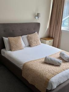 1 dormitorio con 1 cama grande y cabecero en The Waverley Inn, en Dingwall