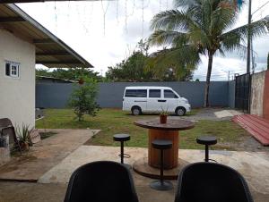 a patio with a table and chairs and a white van at Hostal familiar M&M los algarrobos in Los Algarrobos