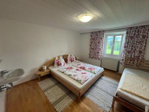 a bedroom with a bed and a sink and a window at Ferienhof Mitterbauer in Mondsee