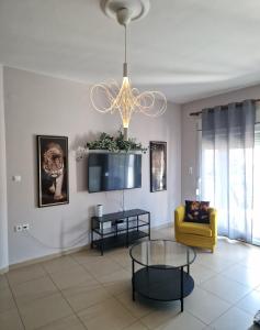 a living room with a chandelier and a yellow chair at Grey House in Prinos