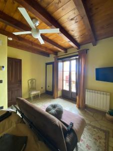 a living room with a ceiling fan and a couch at La Casa del Campillo in Baltanás