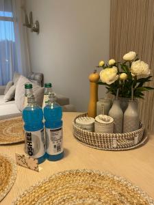 une table avec des bouteilles d'eau et des vases dessus dans l'établissement Apartament Sikorki, à Sianożęty