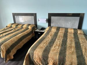 two beds sitting next to each other in a room at crown inn in Memphis