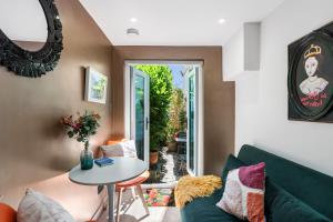 a living room with a green couch and a table at Tiny House with Parking & Patio by Cool Bloo in Brighton & Hove