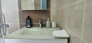 bagno con lavandino e bottiglia di alcol di Blue View a Qeparo