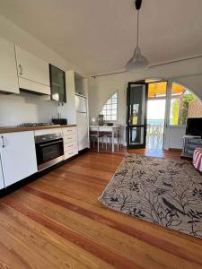 a kitchen with white appliances and a wooden floor at Holiday home in Isola di Albarella 53891 in Palazzo Vianello