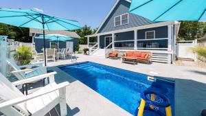 una piscina con sedie e ombrelloni accanto a una casa di Pet-Friendly Pool Bayside Coastal Cottage a Town Bank