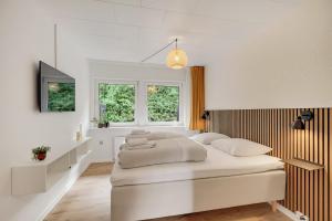 una camera da letto bianca con due letti e una finestra di Billund HomeStay a Billund