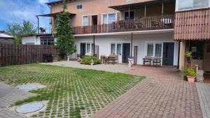 a house with a yard with a patio at Pokoje Gościnne Łeba u Michała in Łeba