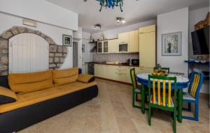 a living room with a couch and a table and chairs at 1 Bedroom Awesome Apartment In Kampor in Kampor