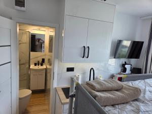 a bedroom with a bed and a bathroom with a sink at STUDIO dla 2 osób in Suwałki