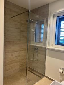 a shower with a glass door in a bathroom at Lulu Lustica bay in Tivat