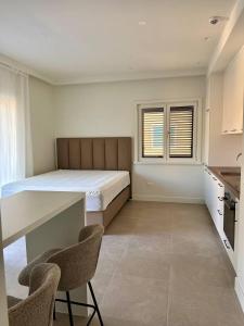 a bedroom with a bed and a desk and chairs at Lulu Lustica bay in Tivat