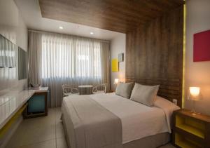 a bedroom with a large bed and a table and chairs at Rio Design Copacabana Hotel in Rio de Janeiro +77 photos