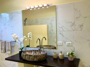 a bathroom with a sink and a mirror at Villa KAMBUSA appartamento SOFIA in Las Galeras