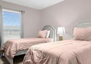a bedroom with two beds and a mirror and a window at 4243 PA - Storey Lake Escape 4BR Pool Home Near Disney in Kissimmee
