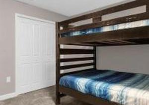 a bedroom with a bunk bed with a wooden bunk bed at 4243 PA - Storey Lake Escape 4BR Pool Home Near Disney in Kissimmee