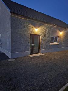 a brick building with a door and a window at Macaldrack's Loft in Dunloy