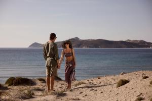 a man and a woman standing on the beach at Hotel Milos Sea Resort in Adamantas