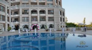 a hotel with a swimming pool in front of a building at Cabacum Beach Private Apartaments in Golden Sands