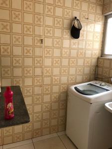 ガラパリにあるApartamento Praia do Morro Guarapariのキッチン(洗濯機付)、窓が備わります。