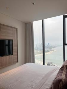 une chambre avec un lit et une grande fenêtre dans l'établissement Alacater hạ long bay, à Hạ Long