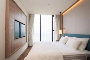 une chambre avec un grand lit et une grande fenêtre dans l'établissement Alacater hạ long bay, à Hạ Long