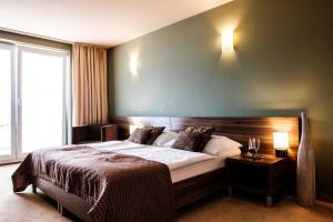 a bedroom with a large bed and a large window at Hotel Comfort with free Wellness and Fitness Centrum in Nitra