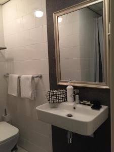 a bathroom with a sink and a mirror and a toilet at France Hotel in Amsterdam