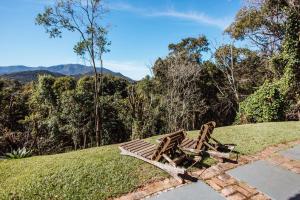 a wooden bench sitting on top of a grassy hill at Smart Hotel Reserva Santo Antônio do Pinhal in Santo Antônio do Pinhal