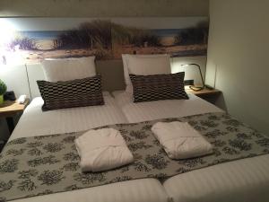 ein großes Bett mit zwei weißen Kissen darauf in der Unterkunft France Hotel in Amsterdam