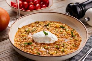 a bowl of rice with sour cream and tomatoes at Hotel Milos Sea Resort in Adamantas