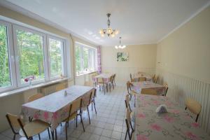 a dining room with tables and chairs and windows at Dom Wczasowy Lech in Susiec