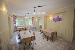 a dining room with tables and chairs and windows at Dom Wczasowy Lech in Susiec +13 photos