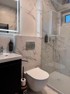 Un baño con inodoro, lavabo y ducha. en Turawa Lake Apartments, en Turawa